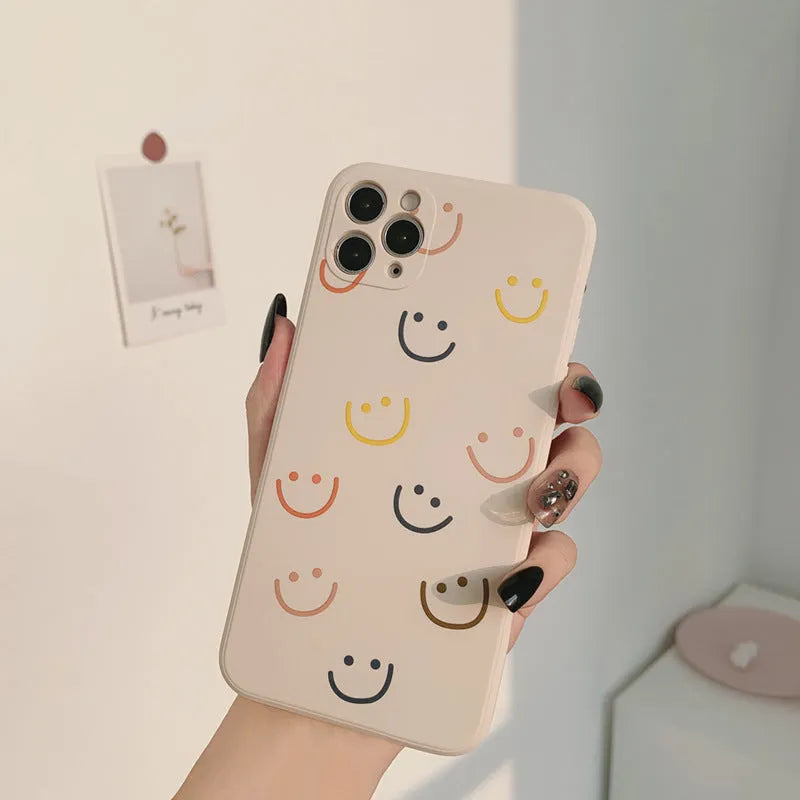 Painted silicone iPhone case showing smiley, rainbow, and watercolour design options