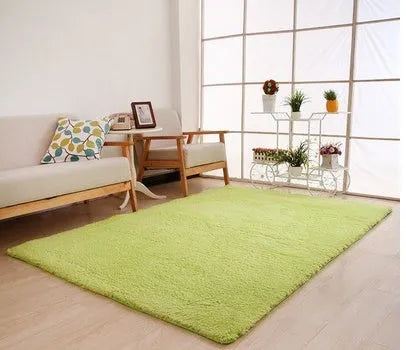 Rectangular solid colour plush carpet with non-slip bottom in beige colour on wooden floor