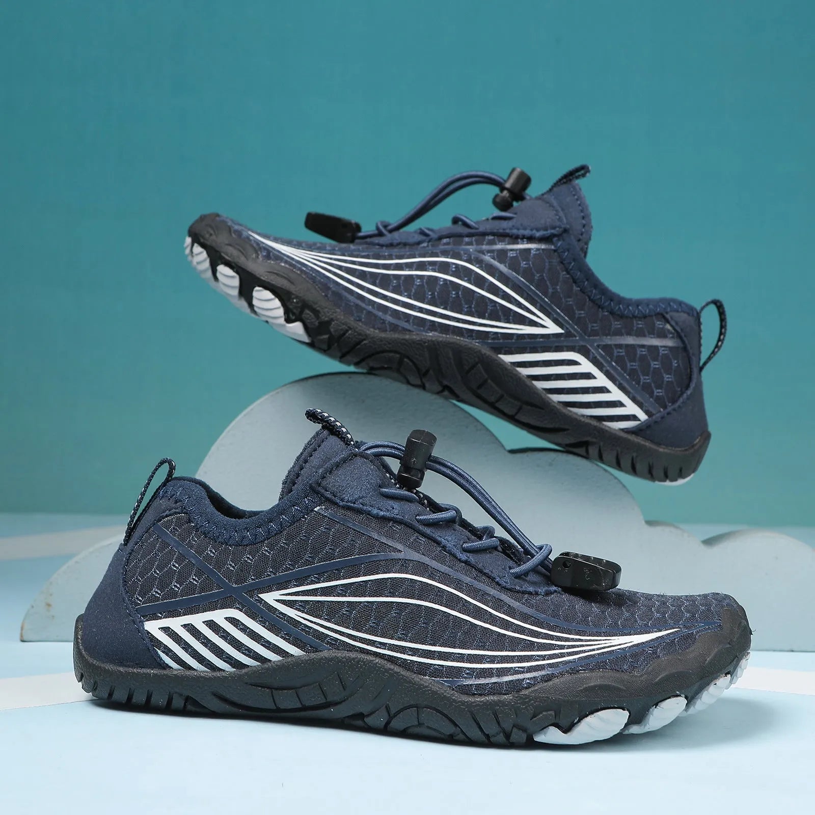Children's quick-drying water shoes with non-slip rubber soles in multiple colours on a sandy beach.