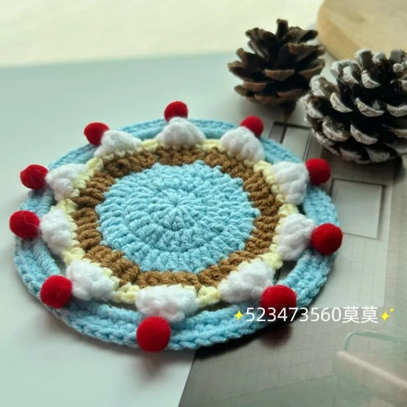 Circular wool felt coaster with cake design, 9 cm in diameter, shown on a table.