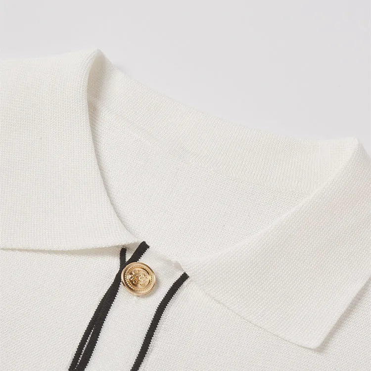 White short-sleeve cardigan with dark contrast pointed lapels, shown on a model.