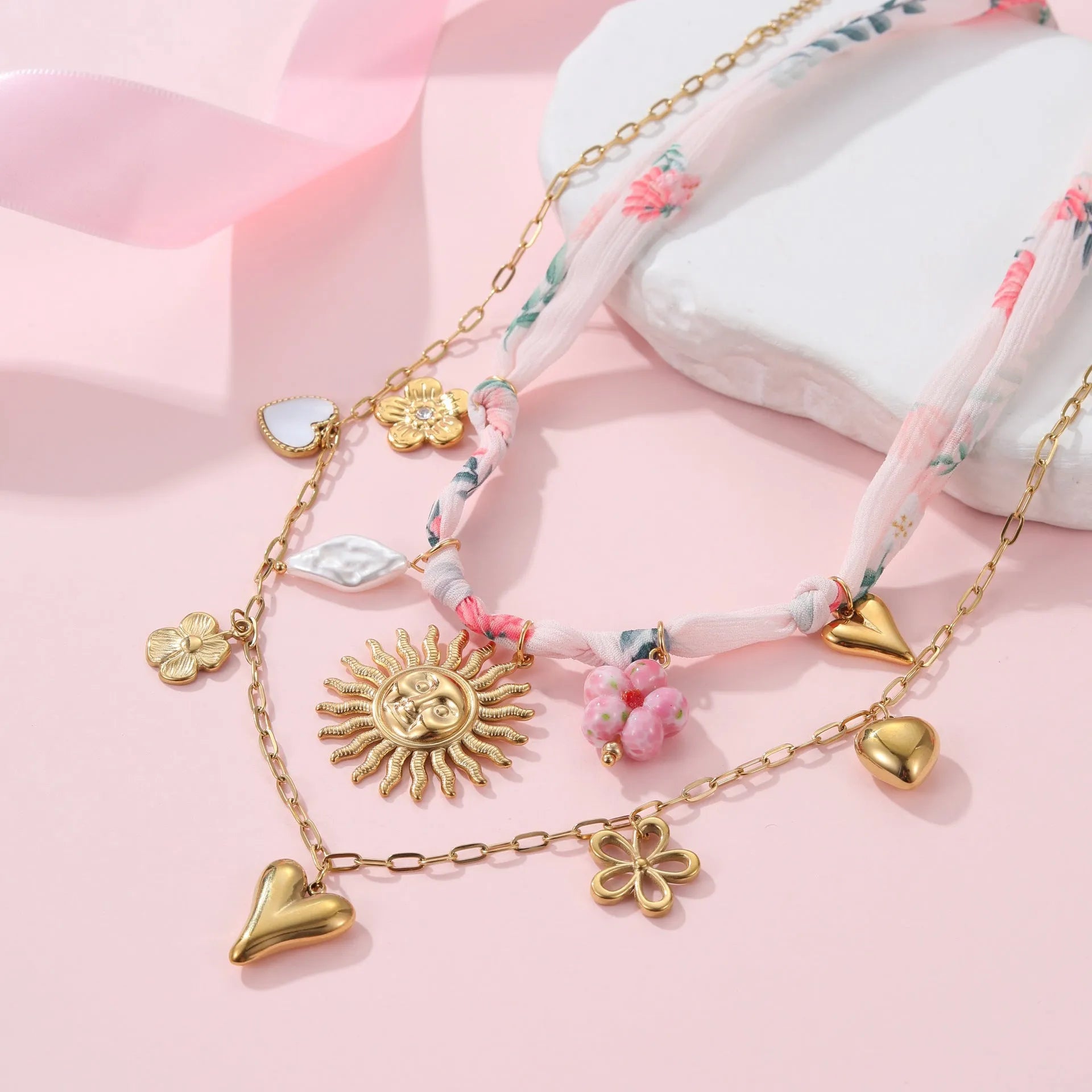 Sun Love pendant necklace in stainless steel with 18K electroplate, showing Heart and Ribbon Sun design options.