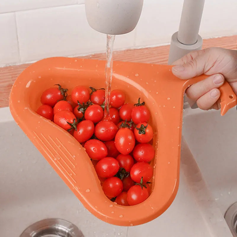 Blue plastic swan-shaped basket hanging over a kitchen sink edge to drain fruit and vegetables.