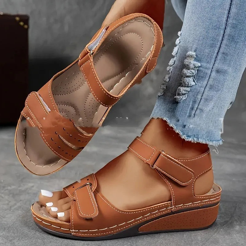 Women's beige thick-soled sandals with adjustable black Velcro straps on a white background.