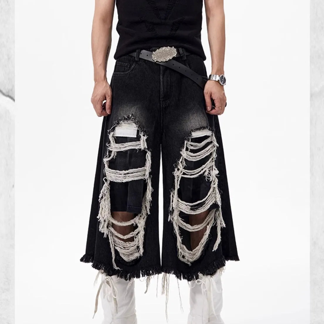 Black wide-leg cropped jeans with distressed patchwork detail and a mid-high waist.