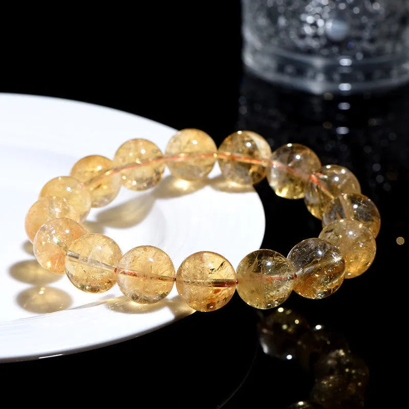 Natural yellow citrine bracelet with geometry-shaped beads in various sizes on a wrist.