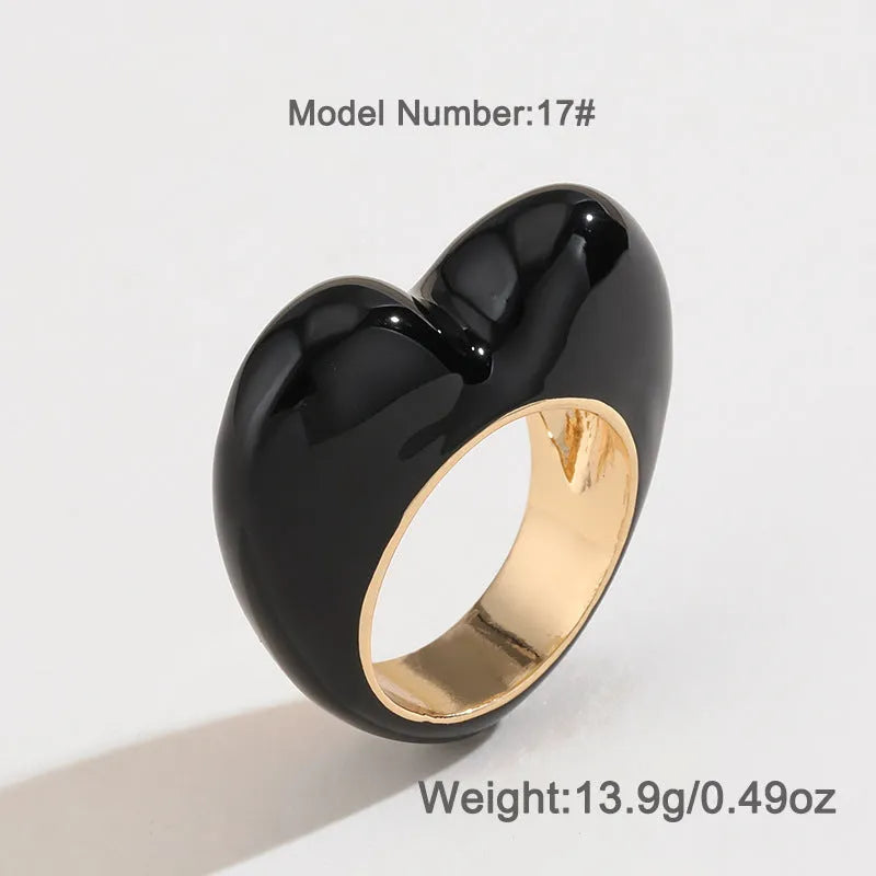 Colourful three-dimensional heart-shaped enamel ring in zinc alloy on a hand.