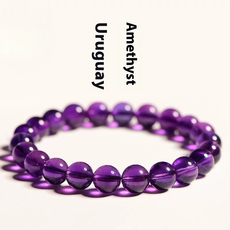Close-up of a polished natural amethyst bead bracelet with a sliding knot closure on a wrist.