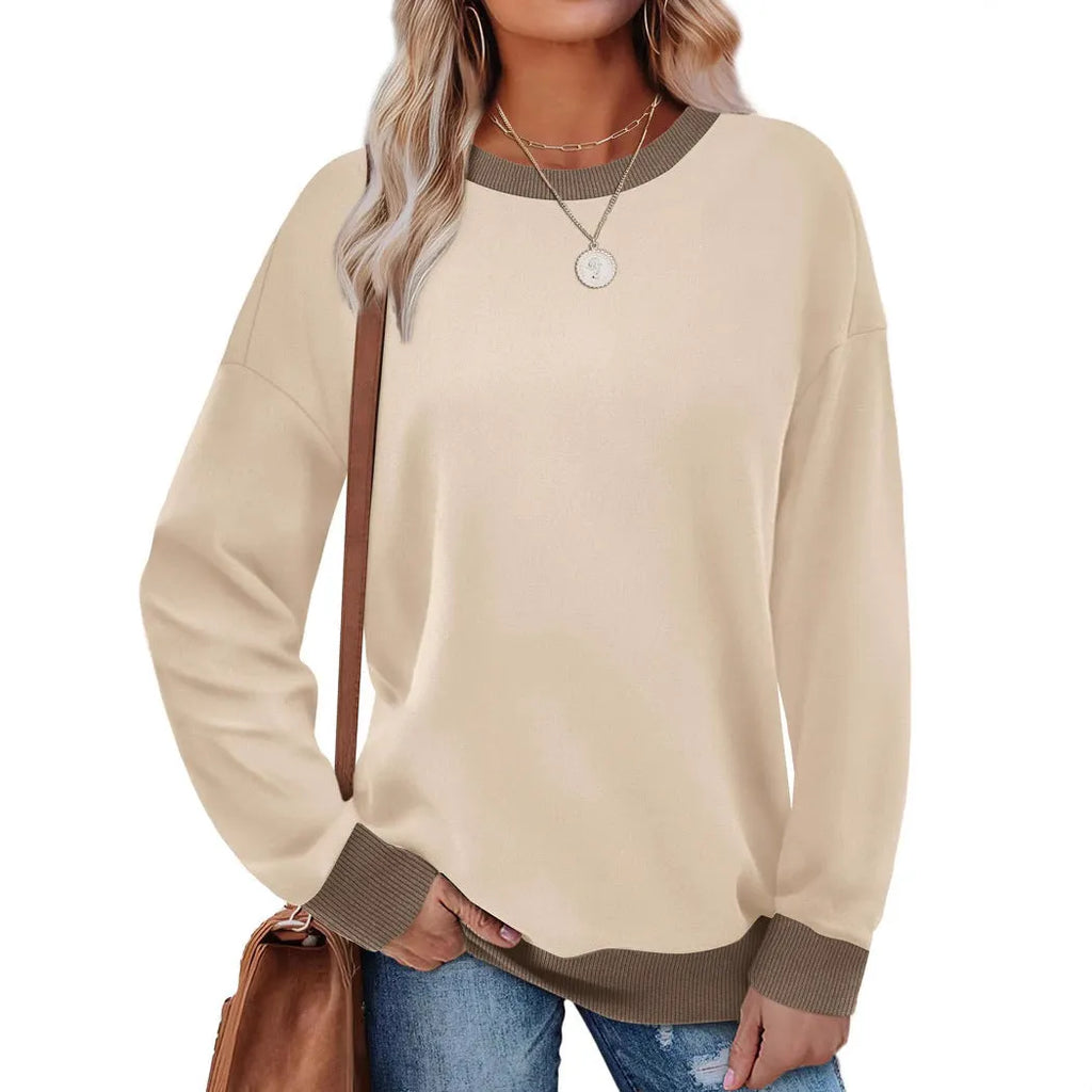 Woman wearing a loose-fitting striped long sleeve top with a round neckline in a grey colour.