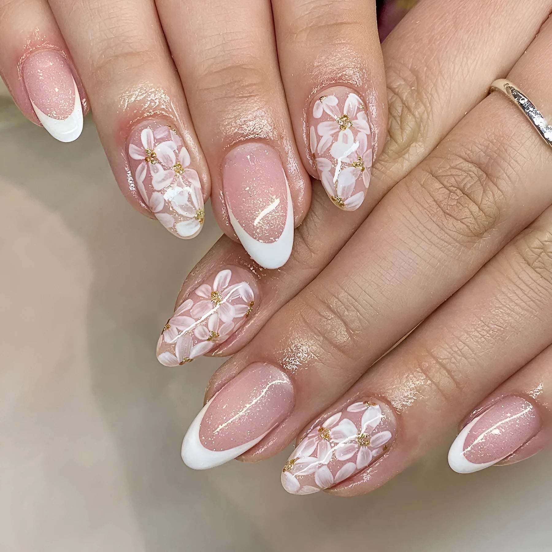 Short glossy almond French style false nails with glittering flower pattern in colour C625