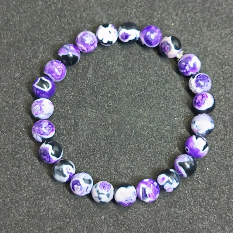 Close-up of a ladies bohemian bracelet with 8mm round glass beads in natural agate colours.