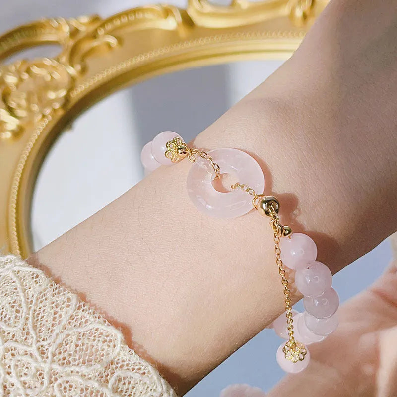 Pink crystal bracelet with peace buckle closure on woman's wrist