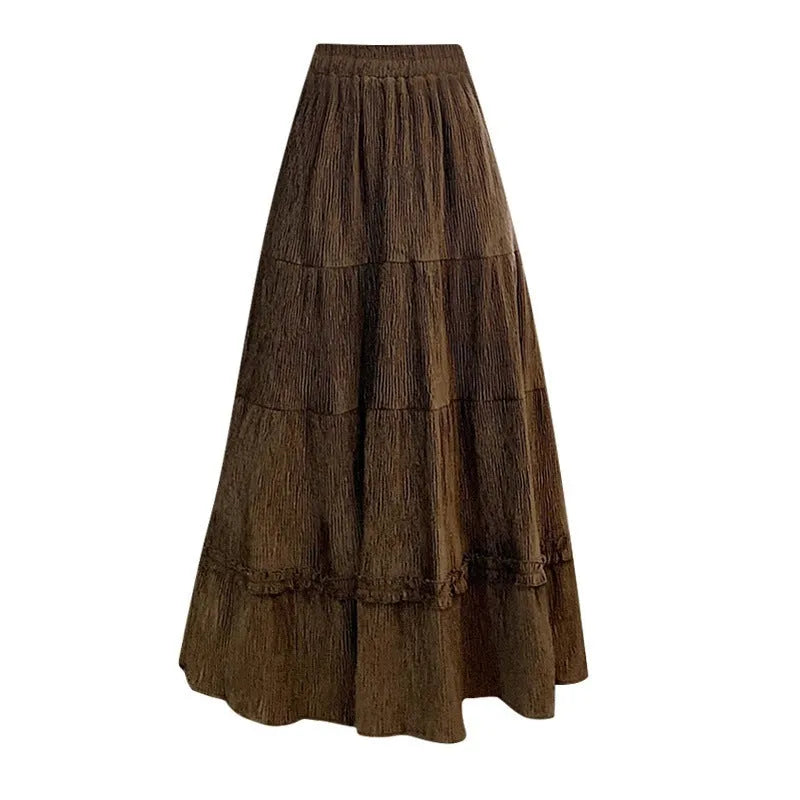 A woman modelling a beige corduroy midi A-line skirt with an elasticated waistband.