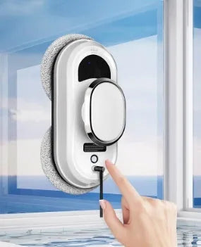White full-automatic high altitude cleaning machine with remote control on a windowsill.