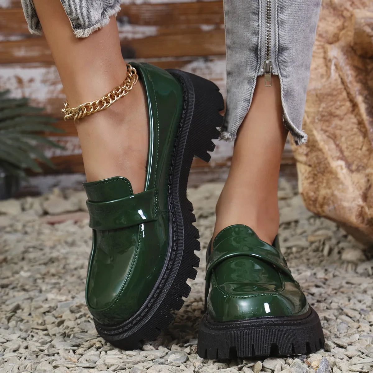 A pair of black plus size slip-on loafers with a chunky mid-heel and thick rubber sole on a plain background.