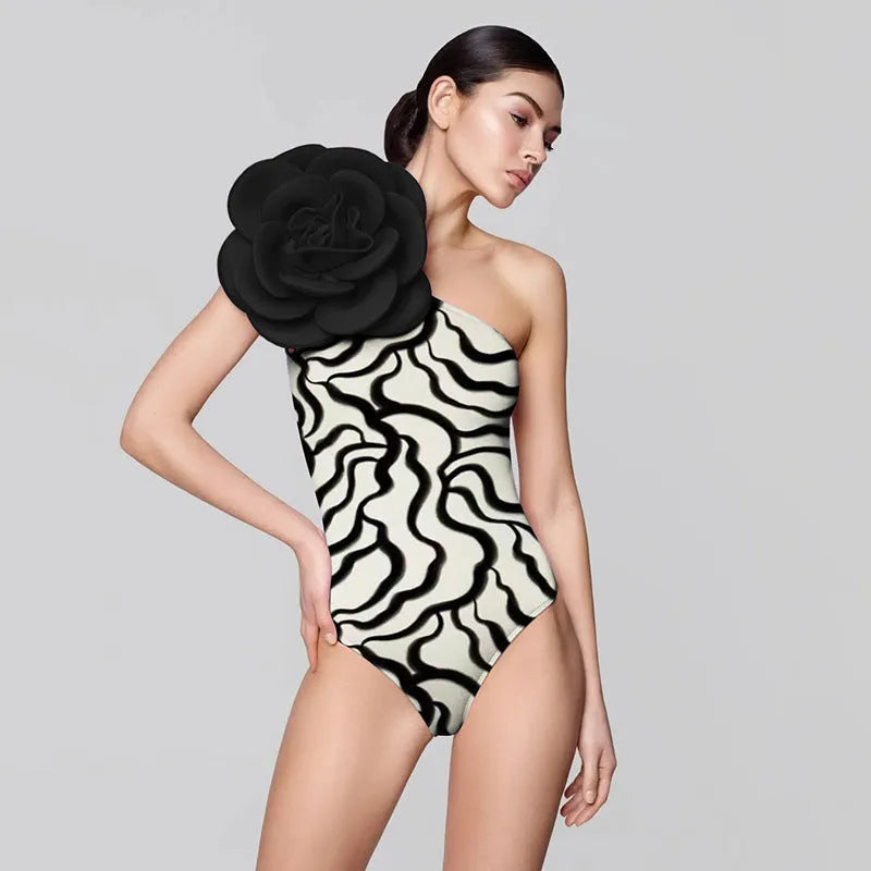 One-piece swimsuit with three-dimensional floral detail in solid colours, sized S to XL.