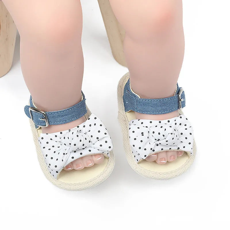 White and black velcro baby shoes showing adjustable straps and low-cut design for toddlers