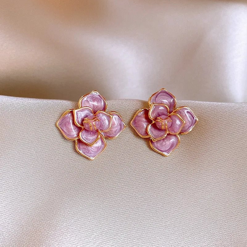 Gold plated stud earrings with a purple oil-spot glaze flower design on a copper base.
