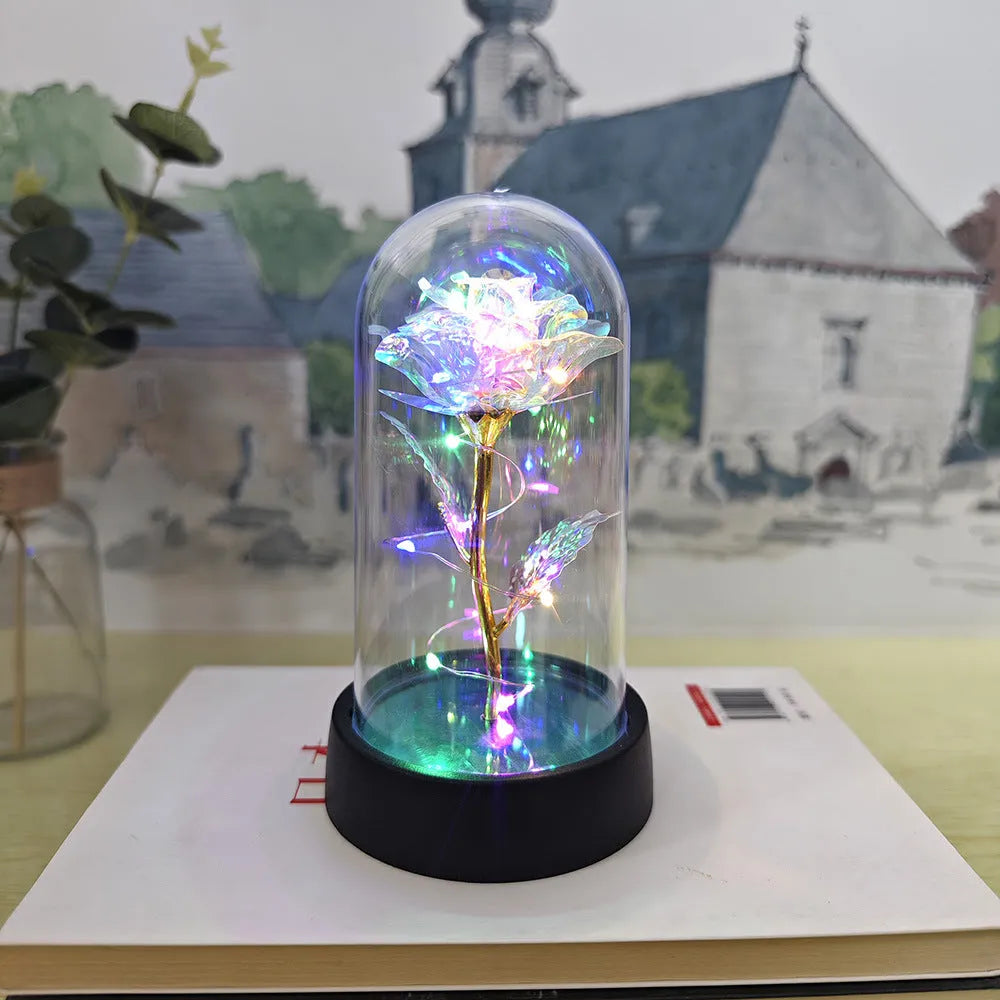 Small decorative night lamp with plastic flowers and a glass-style cover on a black base.