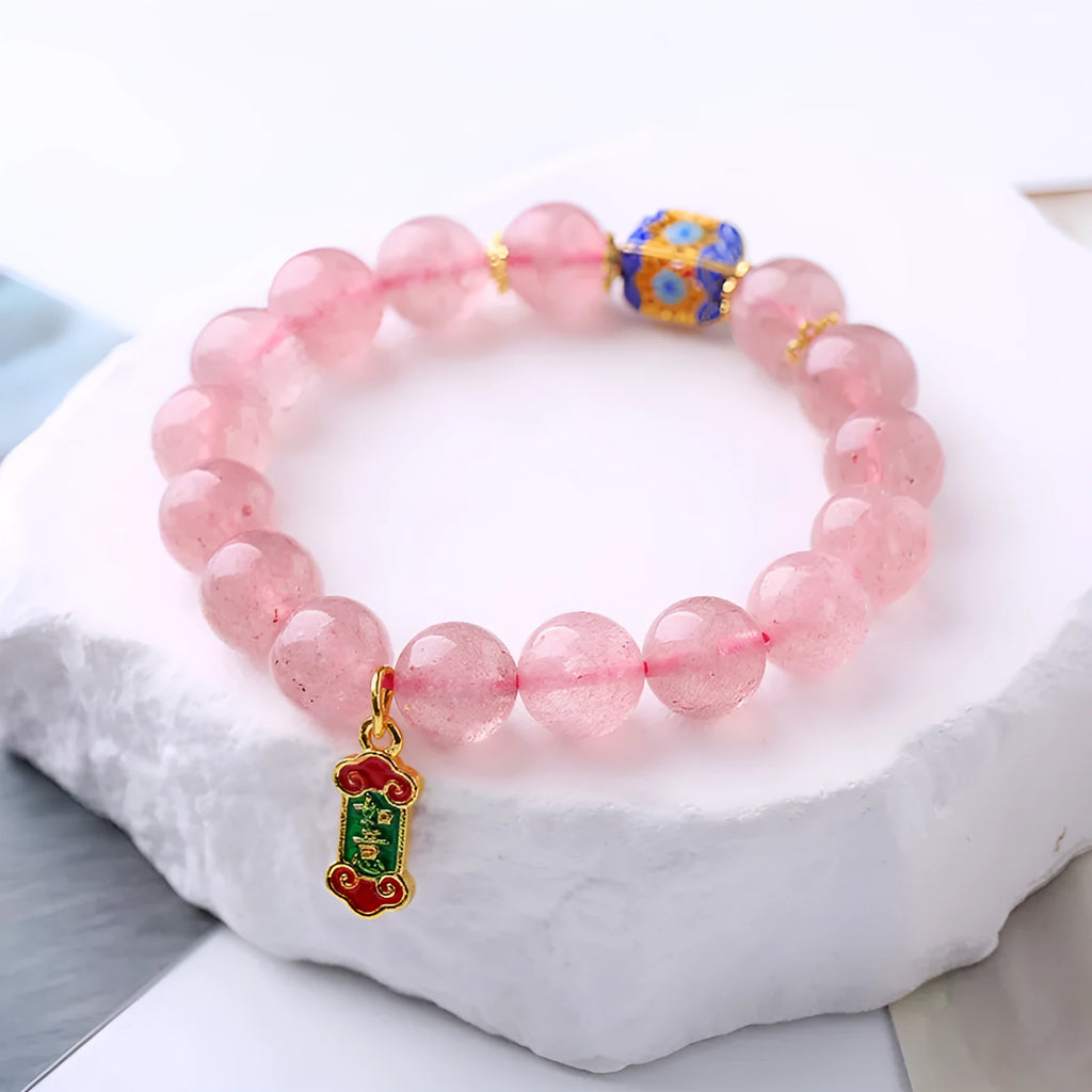 Pink strawberry quartz bracelet with Chinese Ruyi charms and engraved text on wrist