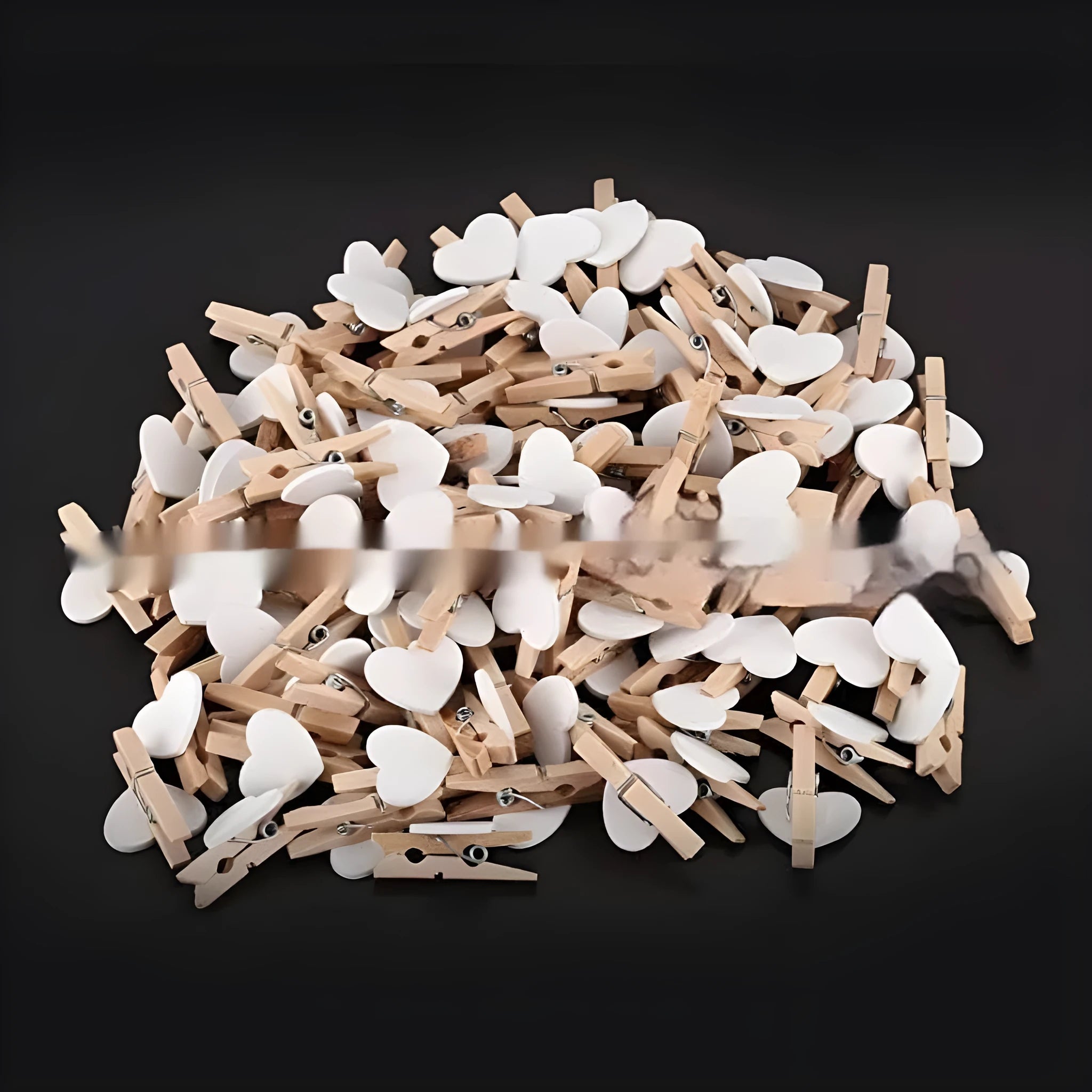 Set of five colourful handmade wooden heart-shaped clips in red, pink, white, and yellow on a wooden surface.