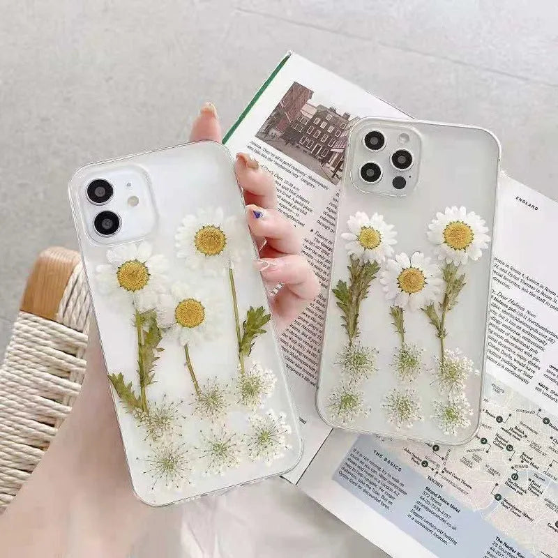 White iPhone case with a raised epoxy daisy floral pattern on the back.
