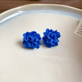 Women's handmade geometric drop earrings with blue resin flower in silver needle colour