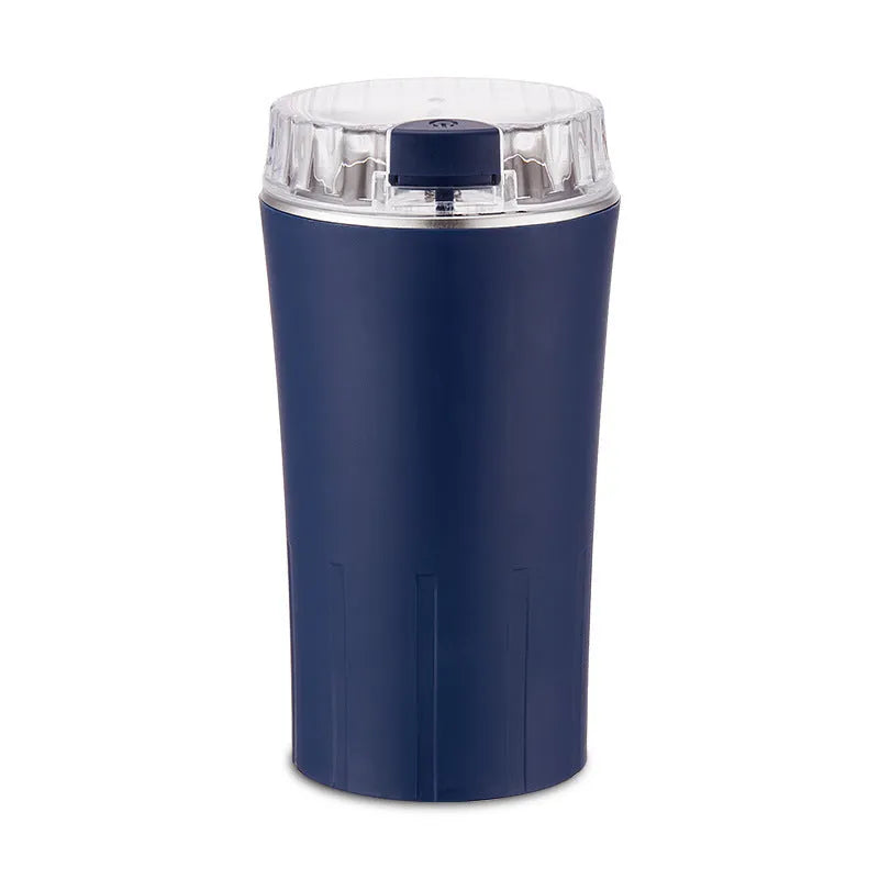 Blue mini flour mill and grain crusher with stainless steel blades on a kitchen countertop.
