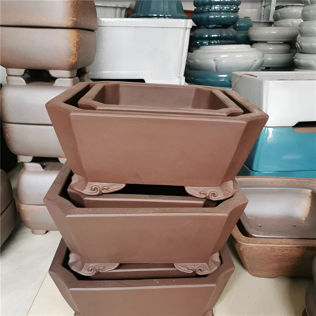 Set of two square stump purple sand flowerpots in brown finish on a flat surface