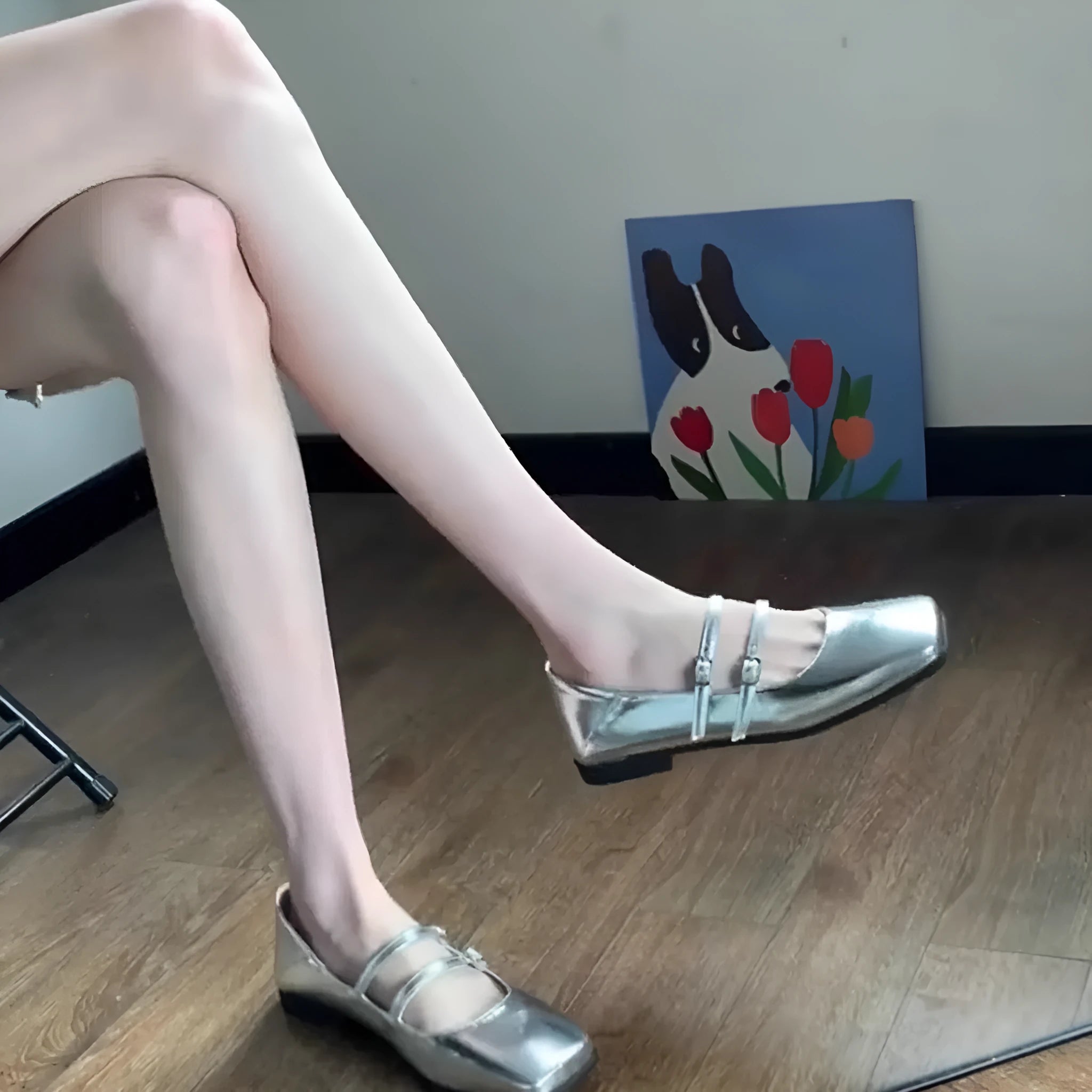 Silver women's leather Mary Jane flats with a cross buckle strap and round toe