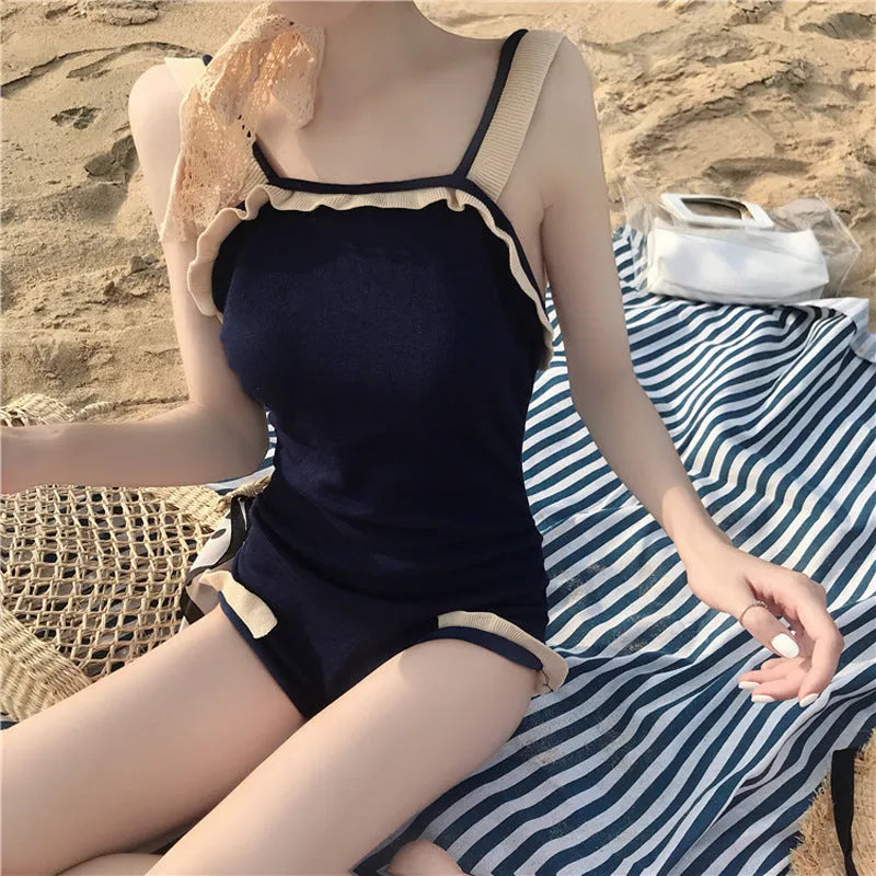 Women's conservative one-piece swimsuit in nylon, shown in black with white edge colour option.