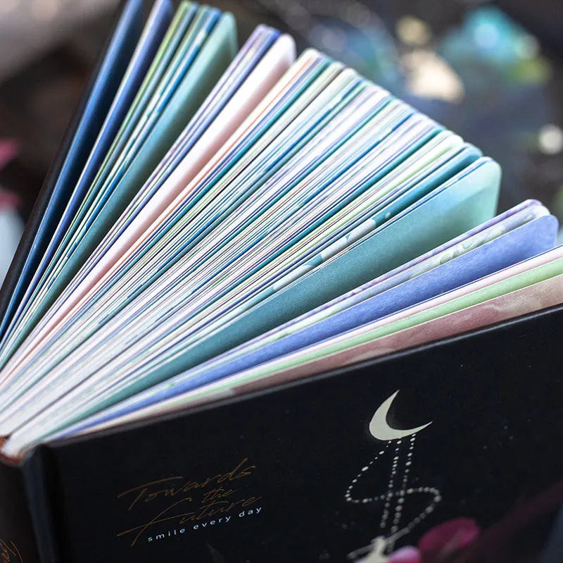 A5 notebook with luminous cover open to show pages filled with colour illustrations.