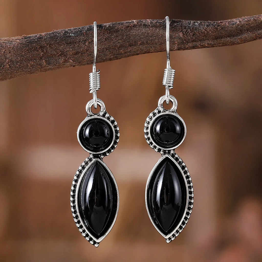 A pair of vintage-style geometric drop earrings with a round detail in black and purple electroplated zinc alloy.
