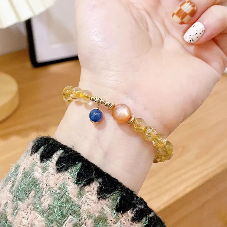 Gold rutilated quartz and sunstone bracelet with round diamond-shaped beads.