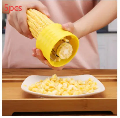 Yellow corn-shaped manual thresher with PP plastic body and stainless steel gear for removing kernels from corn cobs.