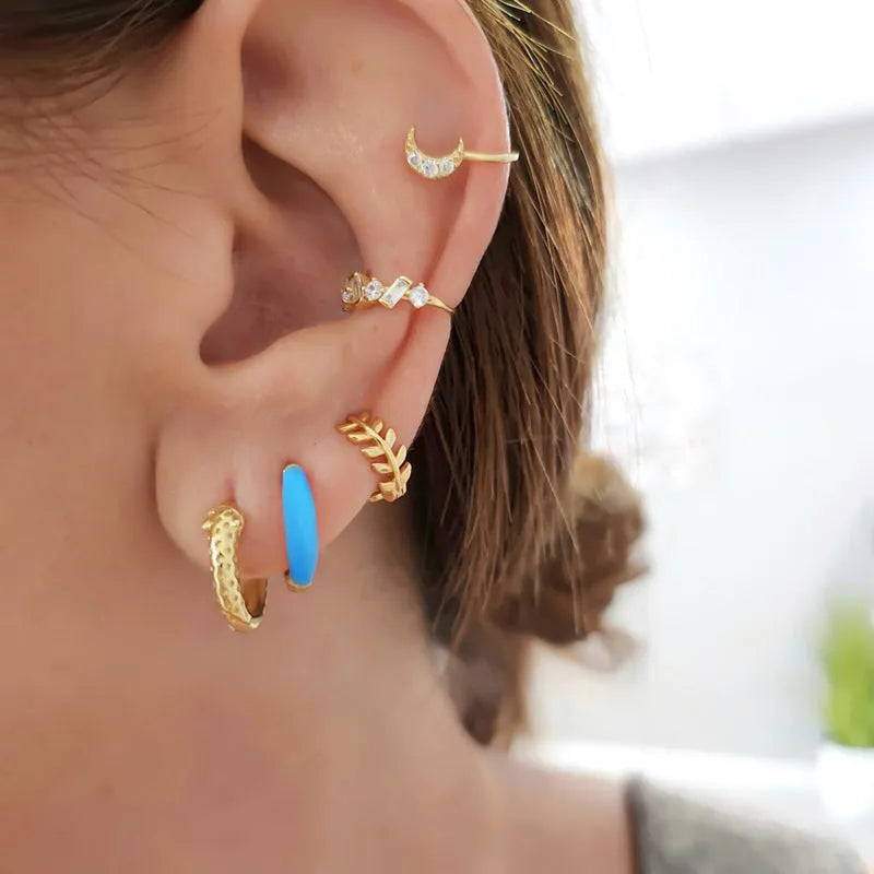A pair of oval-shaped epoxy resin earrings on a U-shaped curved silver hook, showing a marbled colour finish.