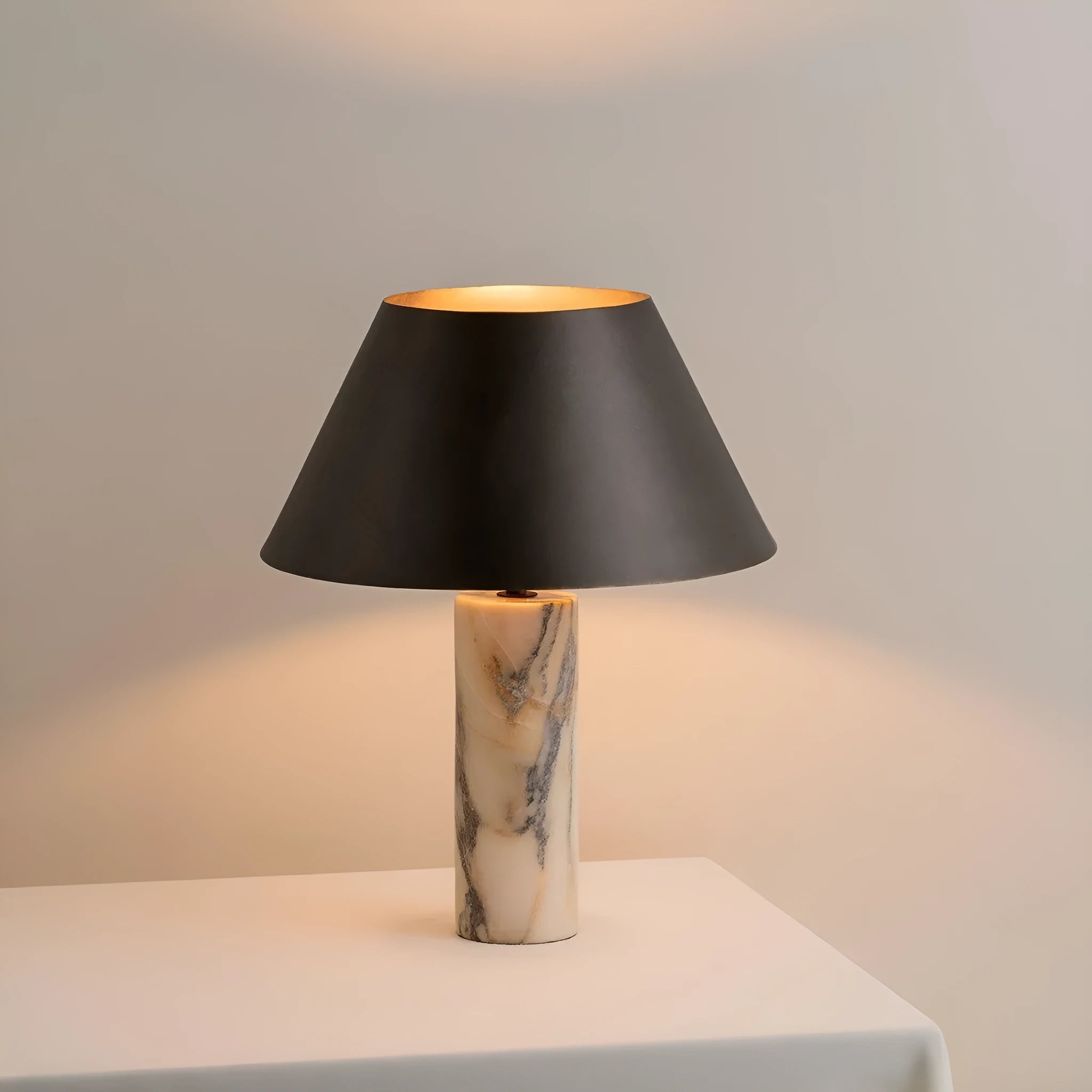 Black modern minimalist table lamp with a solid marble base on a wooden surface.