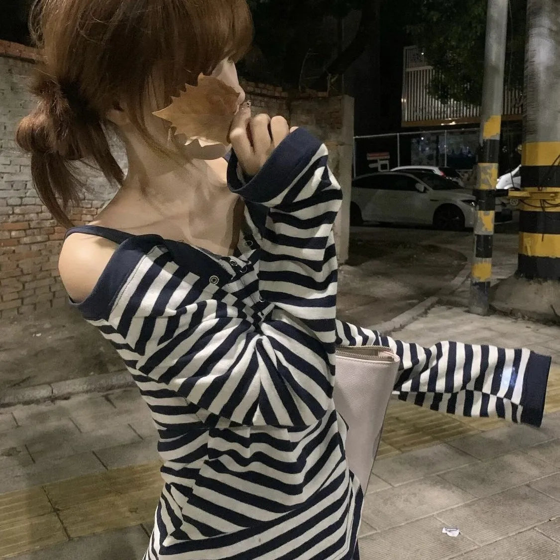 Dark blue women's oversized long-sleeve T-shirt with embroidered stripes and button details.