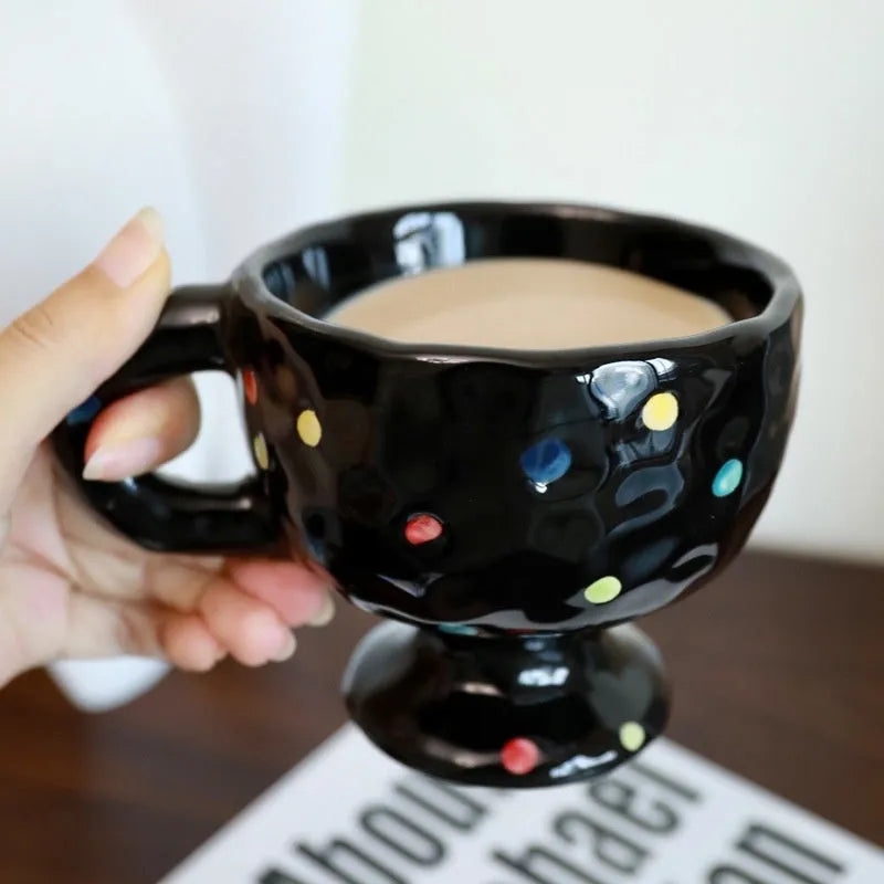 Irregularly shaped hand-pinched ceramic mug in a solid colour, shown on a plain background.