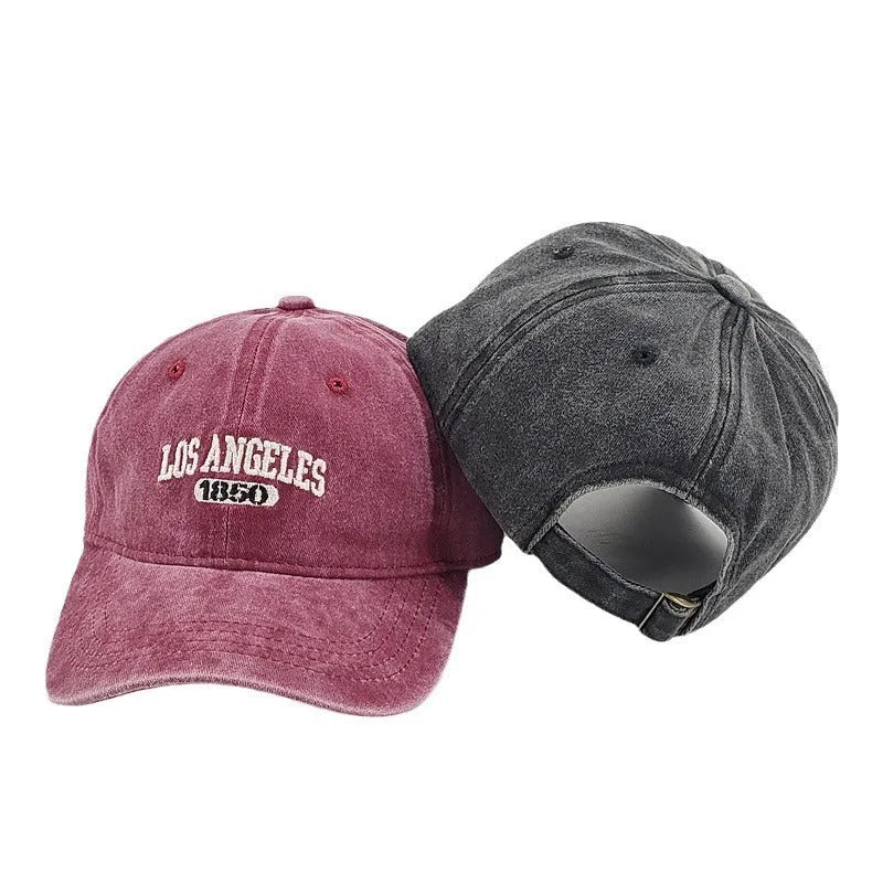 Retro beige peaked cap with embroidered letters, showing distressed fabric texture and adjustable strap.