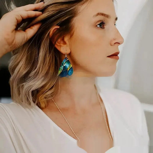 A pair of printed acrylic earrings with a flat branch knot design in a drop shape.