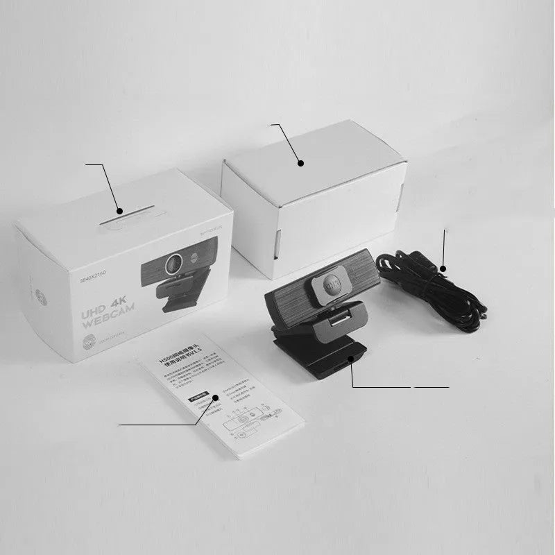Black USB computer webcam with a magnetic privacy cover on a desk.