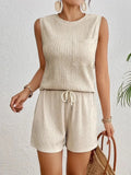 Apricot coloured sleeveless round neck vest and matching shorts set laid flat.