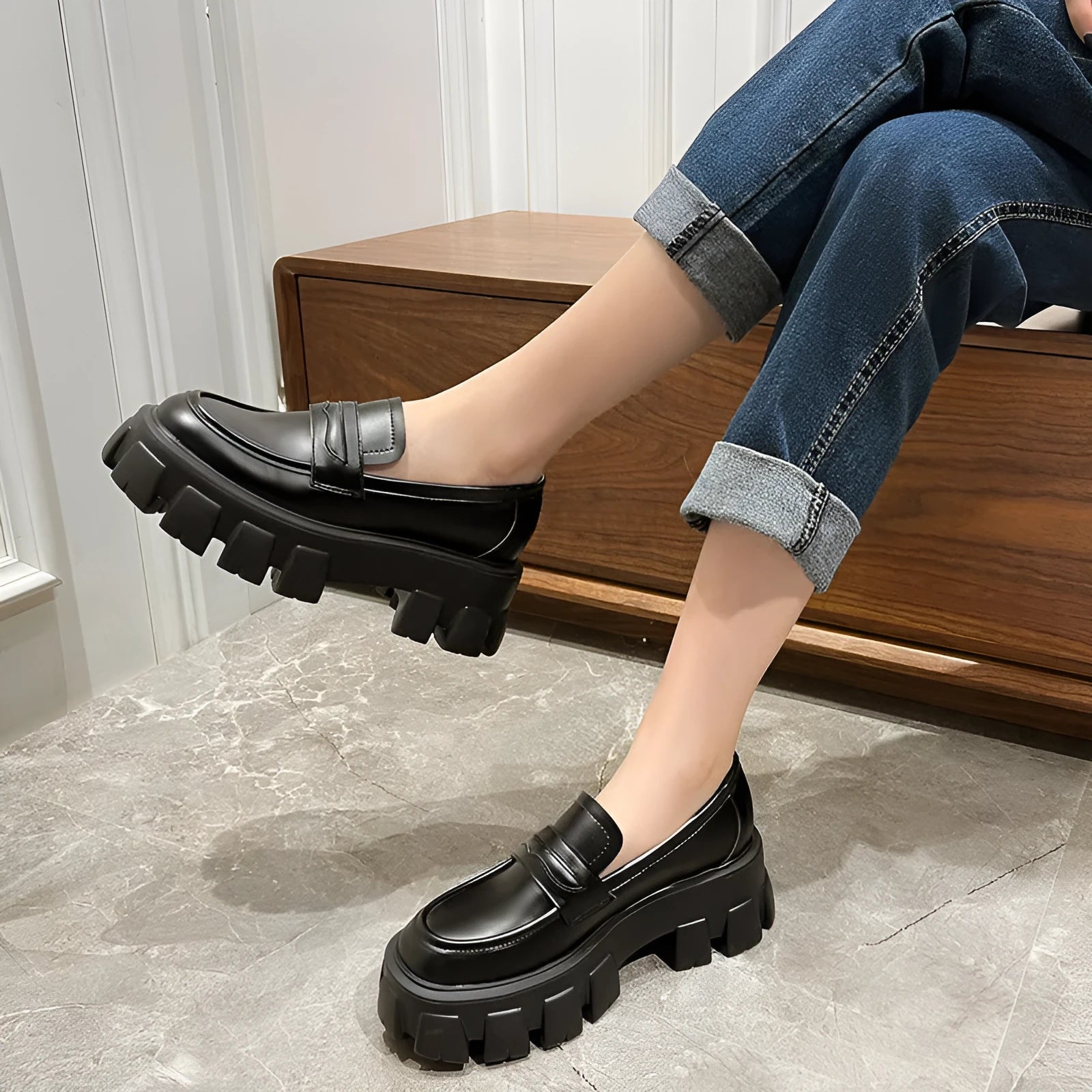 A pair of wide fit patent leather loafers with a flat rubber sole on a neutral background.
