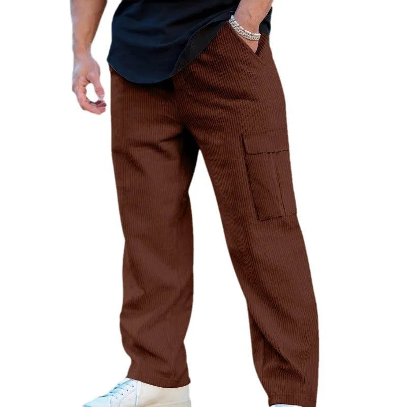 Man wearing navy blue loose-fit corduroy cargo trousers with a drawstring waist.