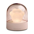 Pink cat paw shaped USB rechargeable night light with soft glow on a desk.