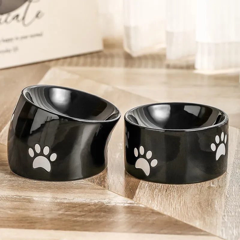 Ceramic cat bowl with cat paw design in black, showing oblique mouth style.