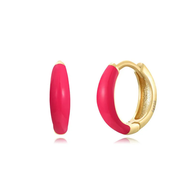 A pair of oval-shaped epoxy resin earrings on a U-shaped curved silver hook, showing a marbled colour finish.
