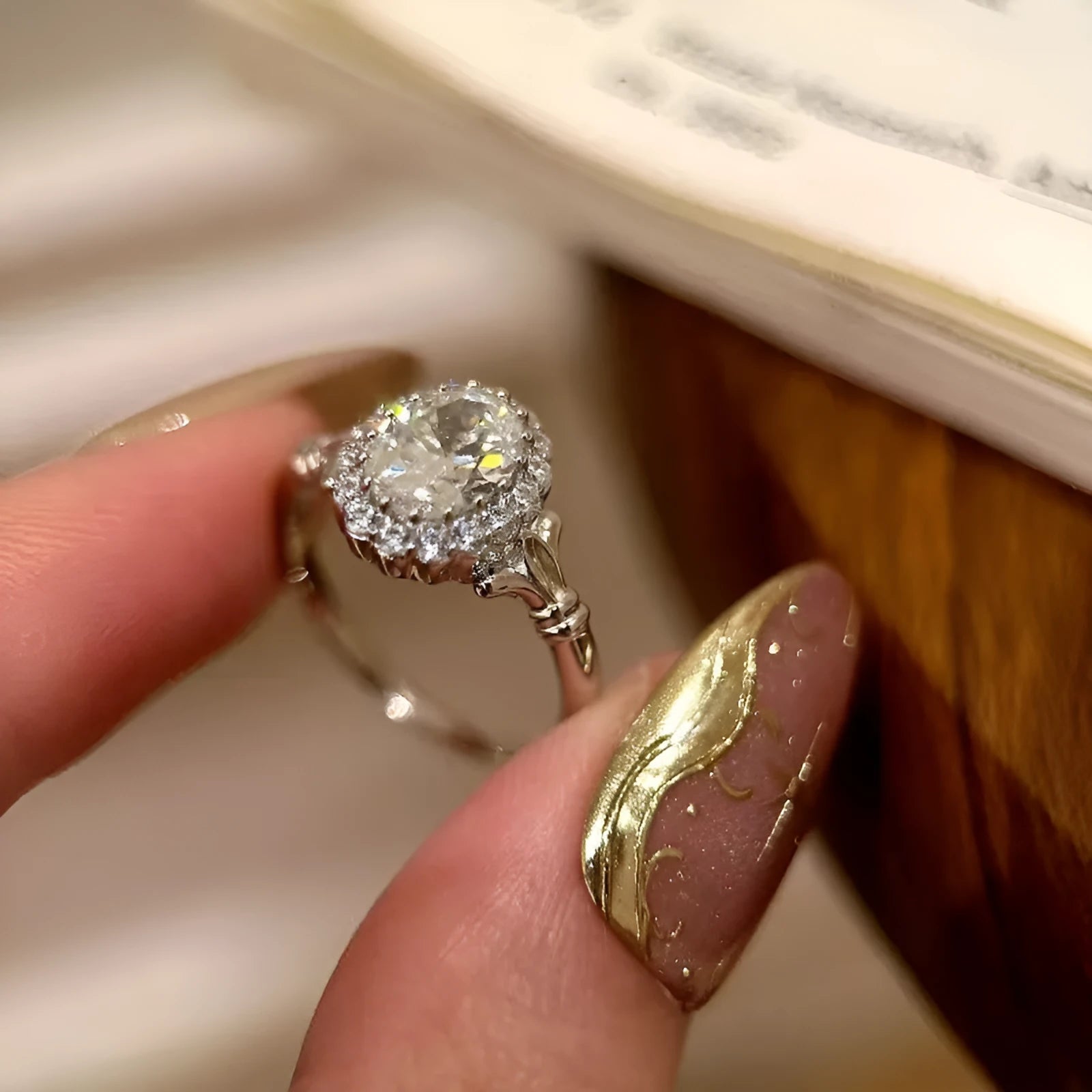 Close-up of a silver geometric ring with a large elliptical diamond on an adjustable open band.