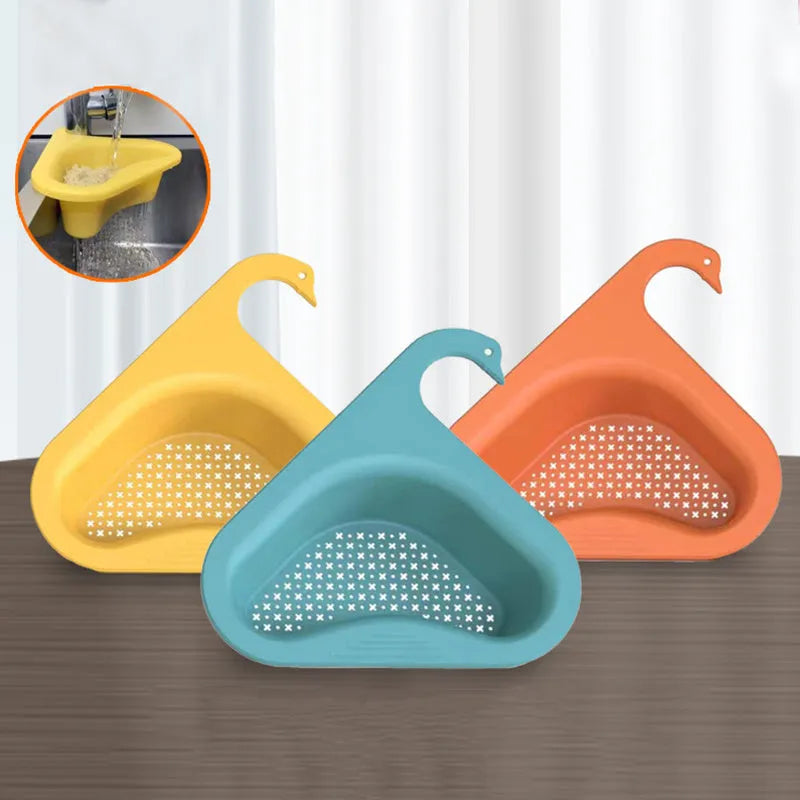 Blue plastic swan-shaped basket hanging over a kitchen sink edge to drain fruit and vegetables.